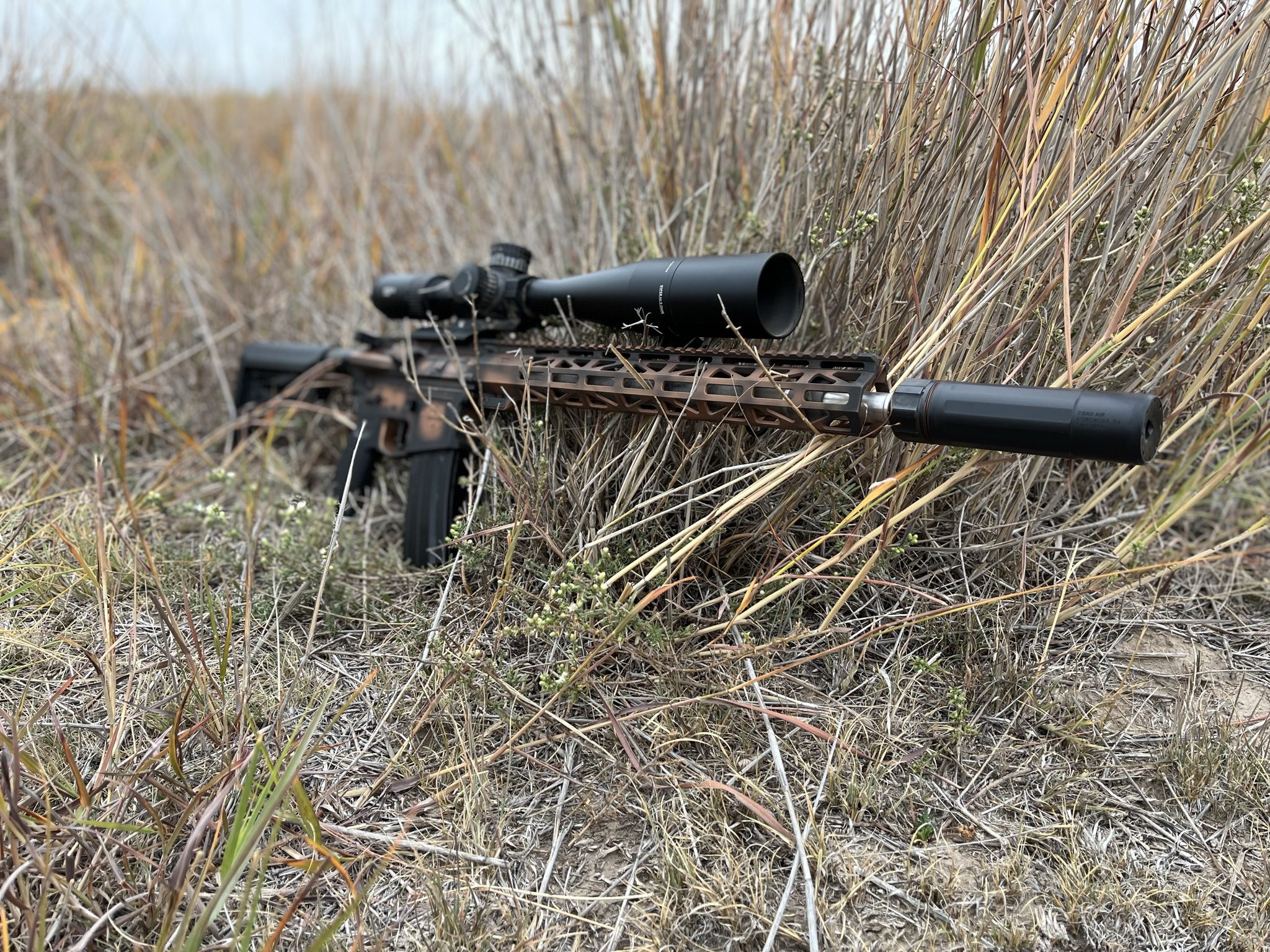 BCA-15 Paladin 6mm ARC rifle with a 16 Inch barrel and Quad 15 handguard, cerakote finished in Leather, equiped with a Magpul MOE SL Carbine stock and showns with a Vortex Viper LHT scope, and the Dead Air Sandman K suppressor. Precision 6mm Rifle, light weight hunting rifle, match grade carbonfiber barrel.